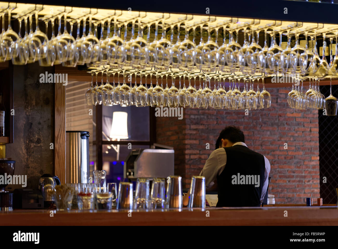 Gruppo di vuoto bicchieri da vino appesi da travi metalliche in un bar Foto  stock - Alamy