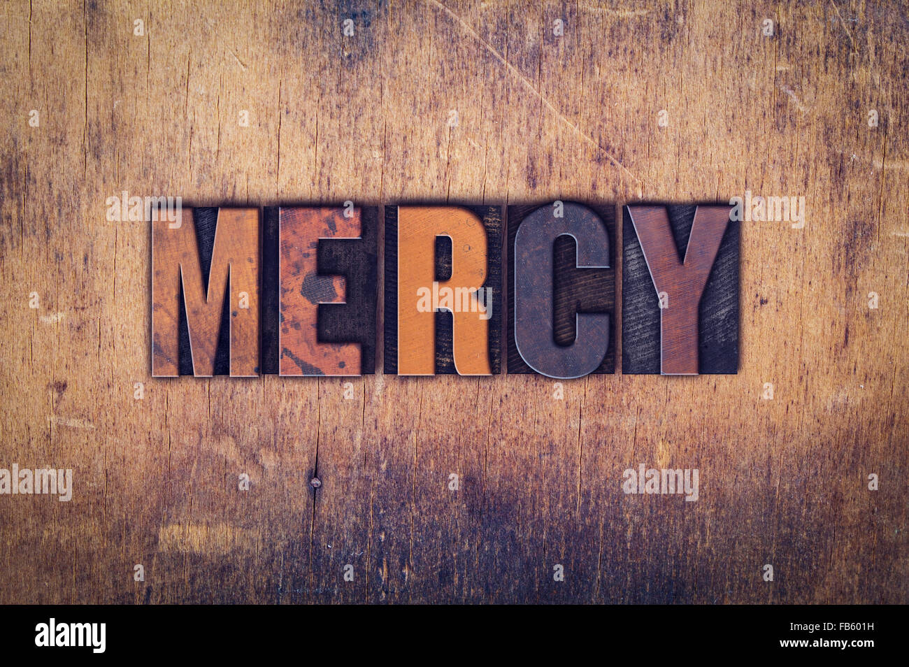 La parola 'Mercy' scritta in presenza di sporco vintage tipo di stampa in rilievo su di un legno invecchiato sfondo. Foto Stock