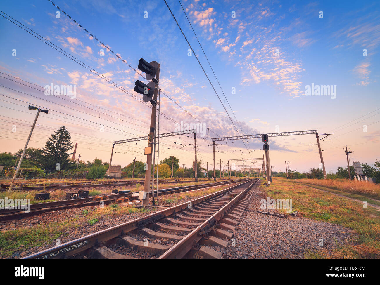 La piattaforma del treno e il semaforo al tramonto. Ferrovia. Stazione ferroviaria Foto Stock