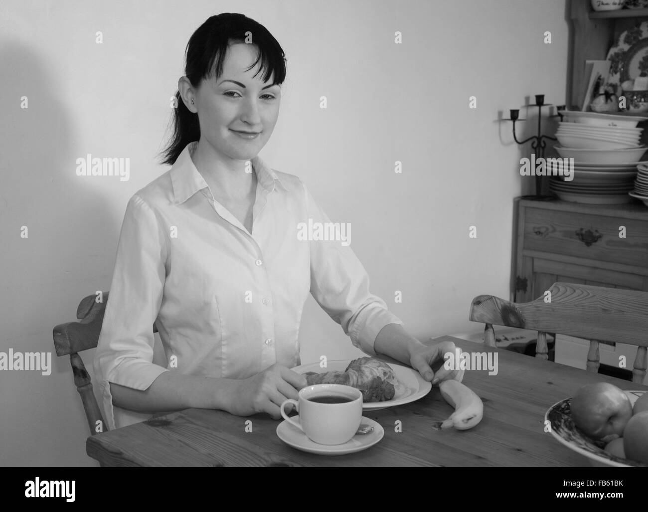 Piuttosto giovane donna caucasica a mangiare una sana colazione con un caffè. Foto Stock