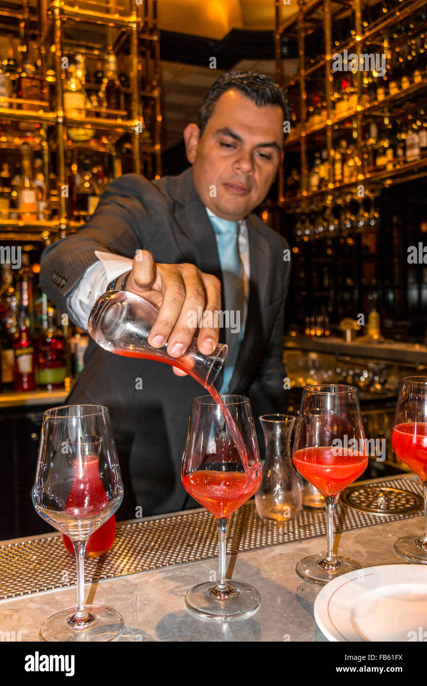 Mixologist crea un Billini Rosso, una fantasia bevanda alcolica con vari liquori, succhi, un nido di caramello e un raspb dorato Foto Stock
