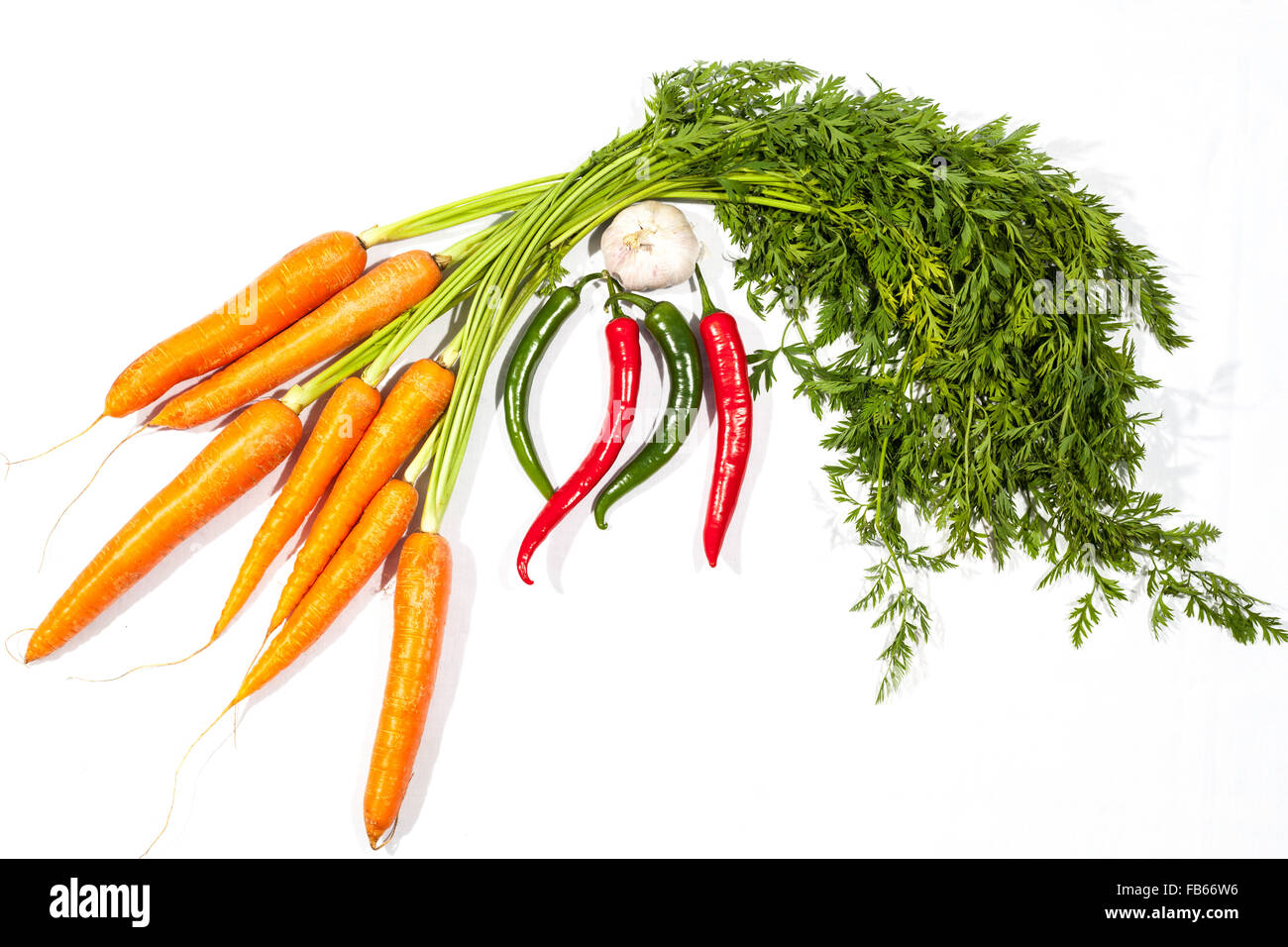 Levetta su carote, peperoncino e aglio su sfondo bianco Foto Stock