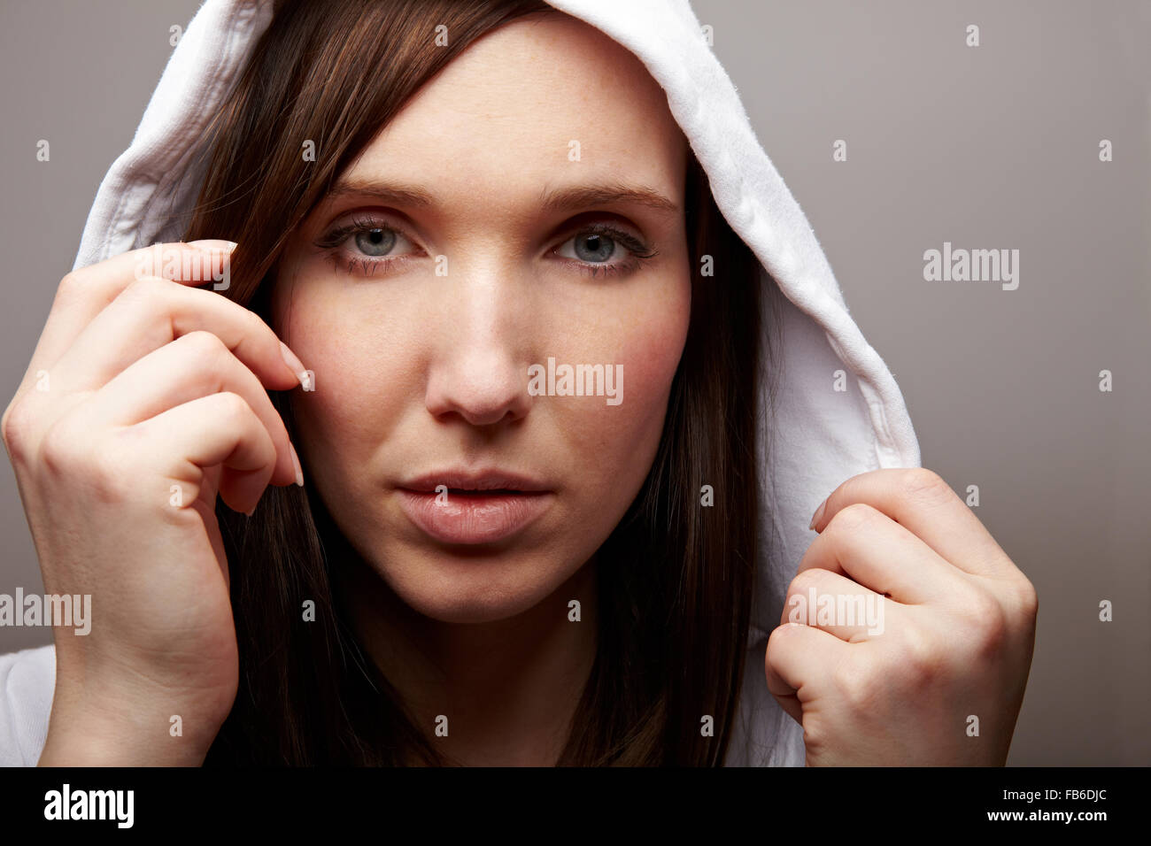 Attraente giovane donna con hoodie cercando seriamente Foto Stock