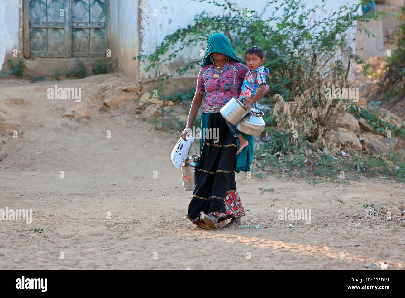 Kacchi Rabari (Desi), Laharia Village, Donna che porta il suo figlio, Distretto di Kutch, Gujarat, India Foto Stock