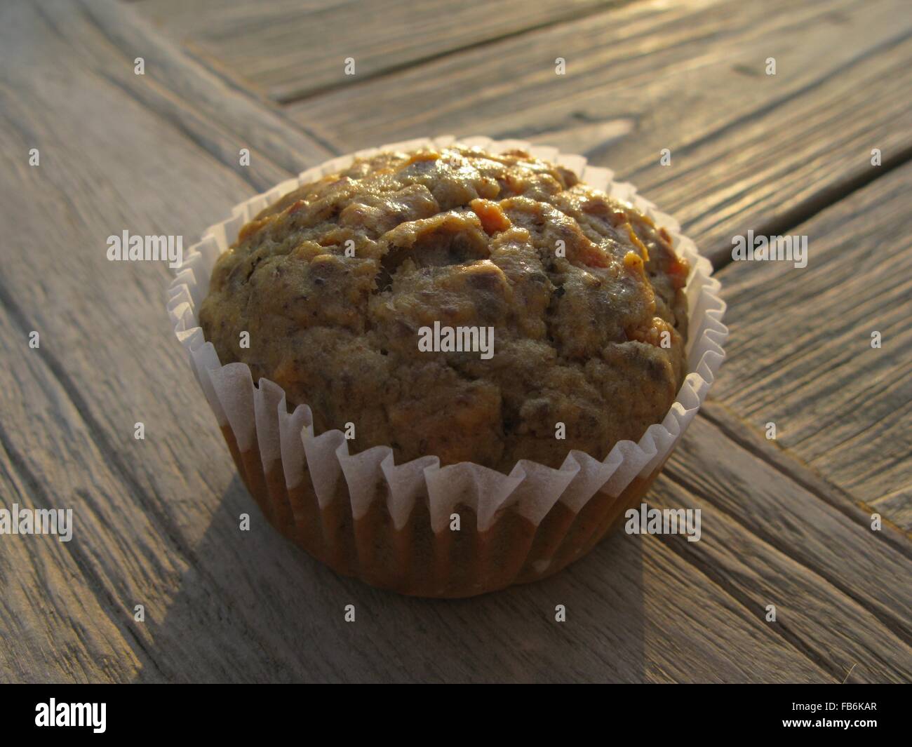 Banana--carota muffin in legno di noce con flaxseeds nella luce del mattino Foto Stock