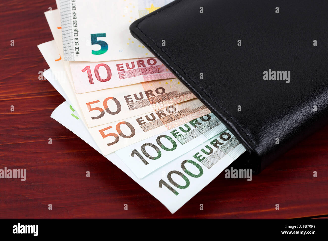 Portafoglio con soldi europei su uno sfondo di legno Foto Stock