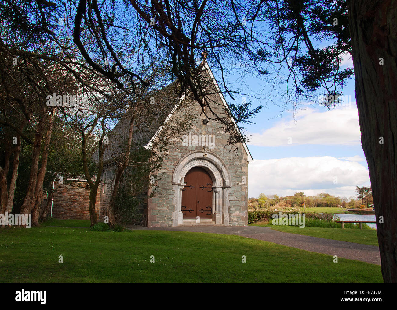Il piccolo San Finbarrs oratorio sulla riva di Gougane Barra Lago, West Cork, Irlanda, raffigurato in una bella giornata con copia spazio. Foto Stock