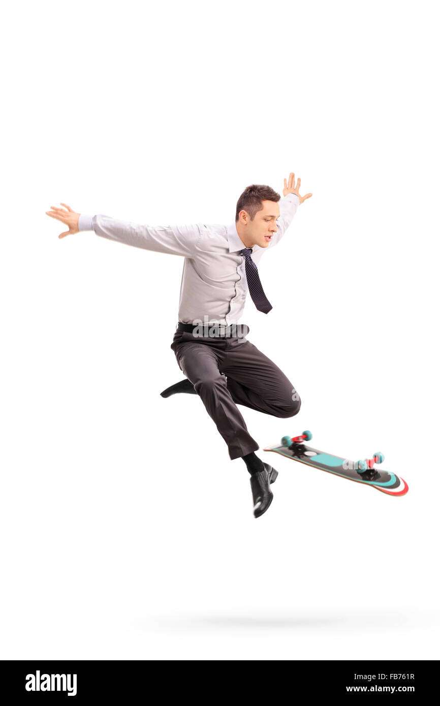 A piena lunghezza Ritratto di una giovane imprenditore compiendo acrobazie con uno skateboard girato a mezz aria isolata su sfondo bianco Foto Stock