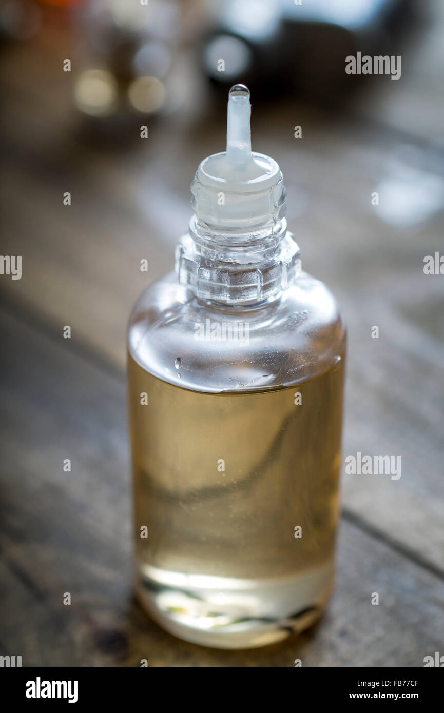 Sigaretta elettronica aroma liquido su sfondo di legno, close up Foto Stock