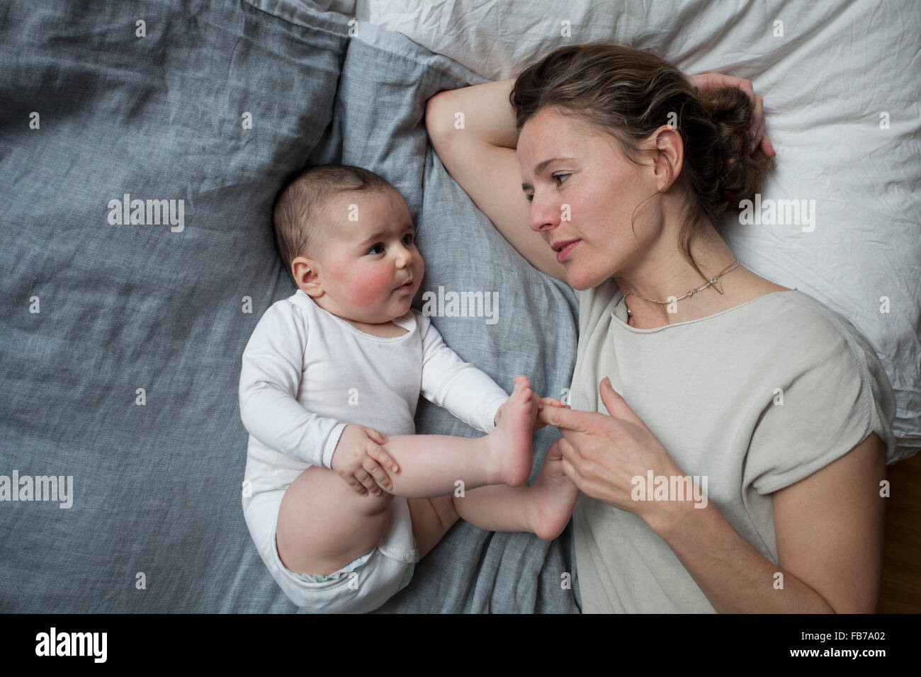 Direttamente sopra il colpo di madre guardando bambina a letto Foto Stock