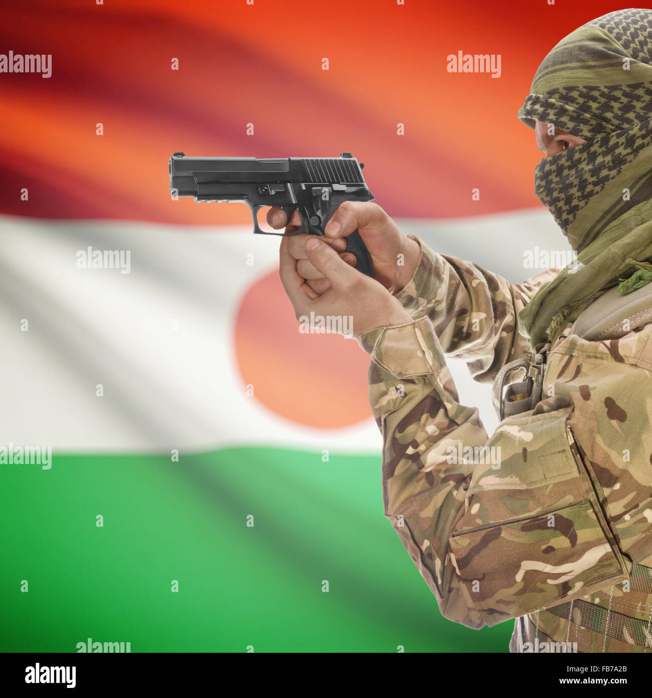 L uomo con la pistola in mano e bandiera nazionale sulla serie di sfondo - Niger Foto Stock