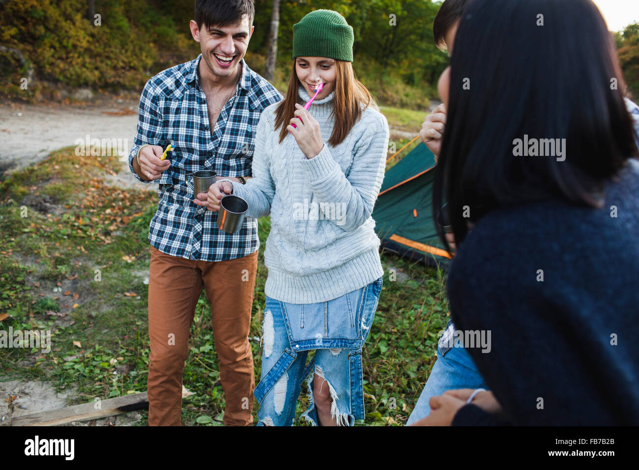 Happy amici spazzolare i denti al campeggio Foto Stock