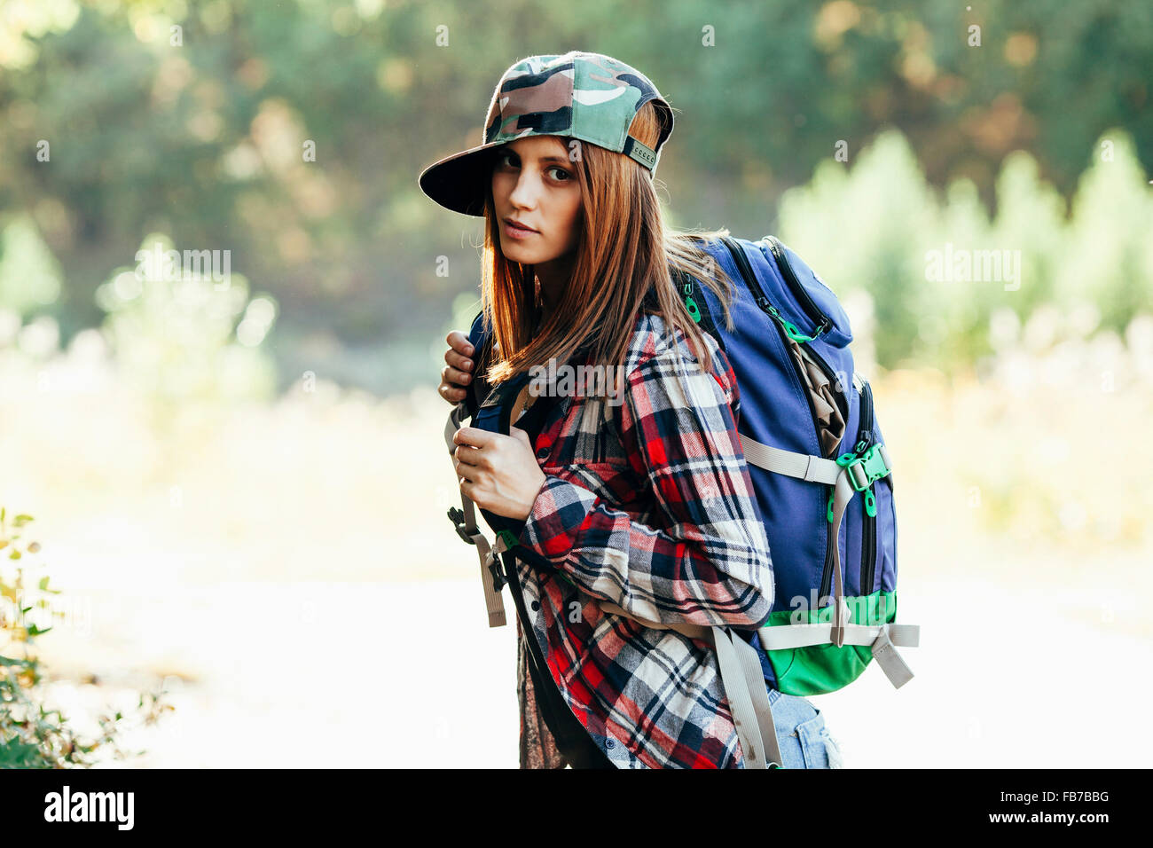 Ritratto di moda giovane donna trekking nella foresta Foto Stock