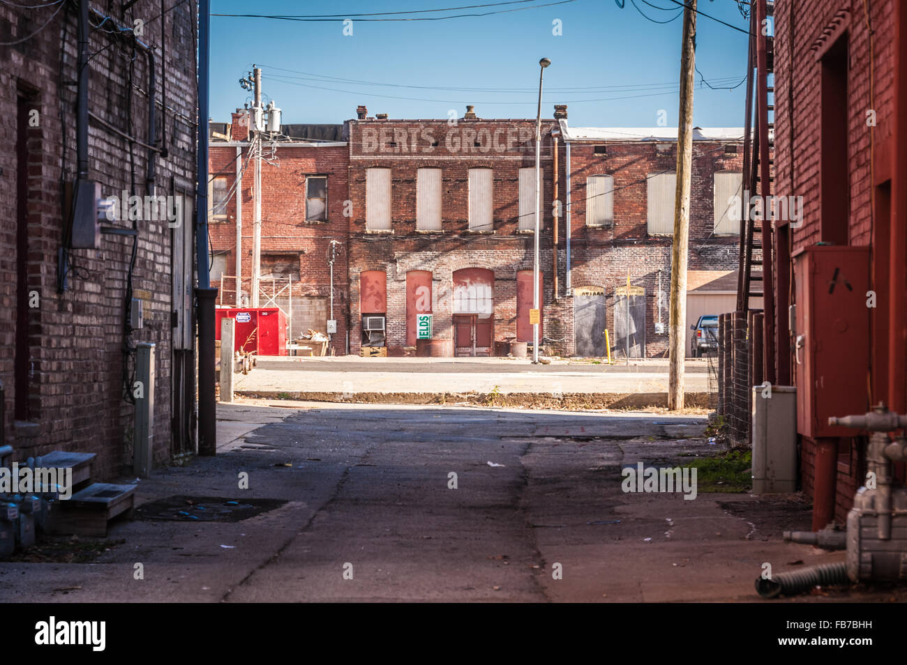 Vecchio, dipinta in mattoni sulla segnaletica sono saliti fino a palazzo visto attraverso il vicolo nel centro cittadino di Muskogee, Oklahoma, Stati Uniti d'America. Foto Stock