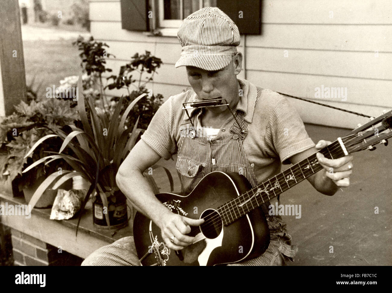 Fotografia storica dell'uomo giocando 'bocca' di organo e una chitarra in 1930 America Foto Stock