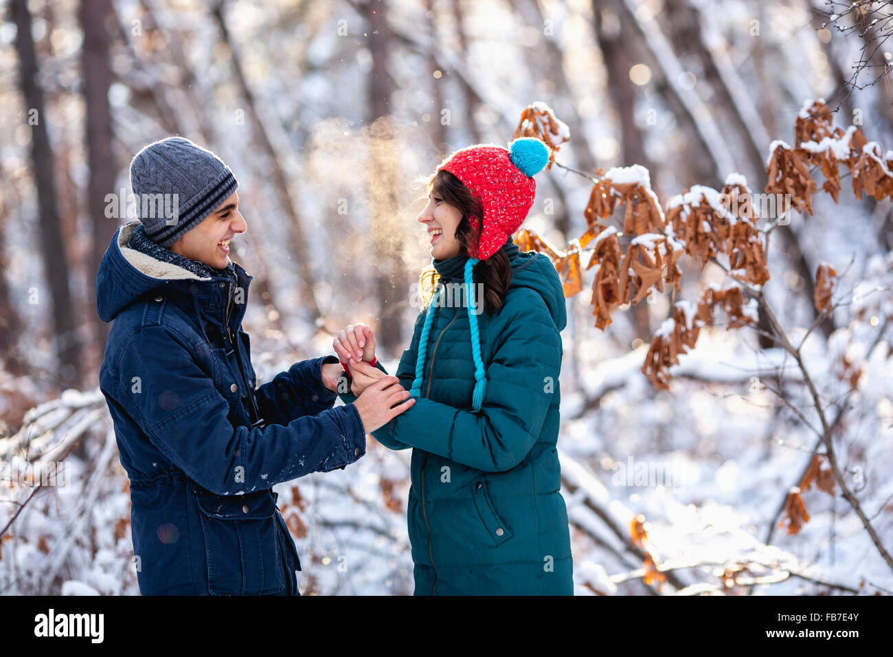 Giocoso coppia giovane tenendo le mani durante il periodo invernale Foto Stock