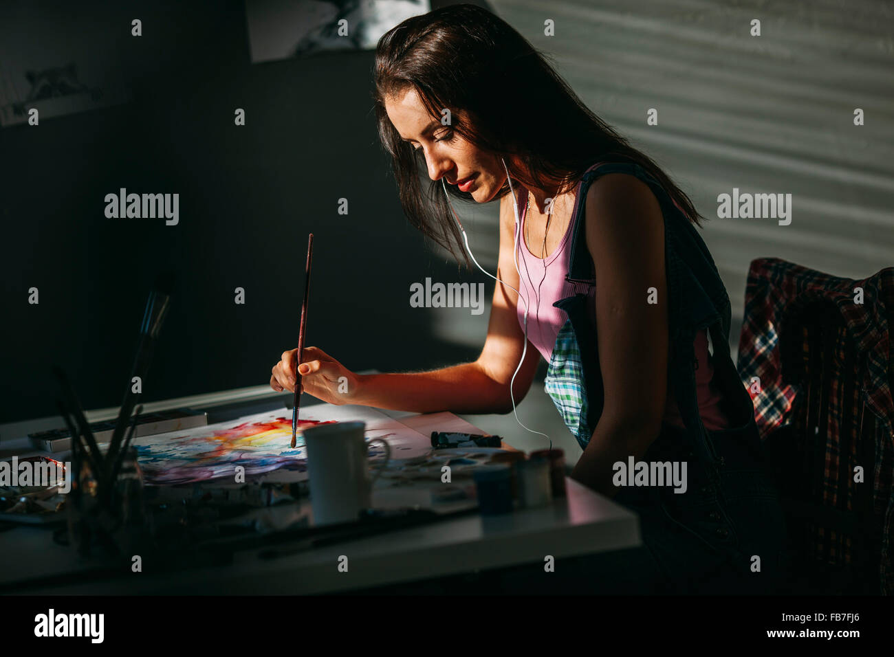 Artista femminile pittura a tavola in art studio Foto Stock