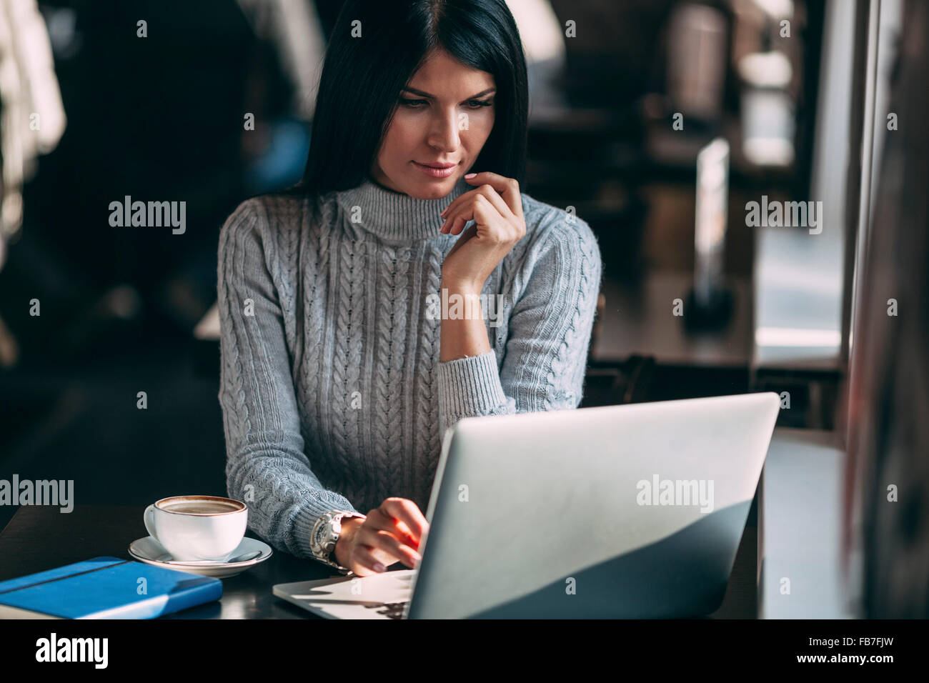Giovane imprenditrice utilizzando laptop a tavola in cafe Foto Stock