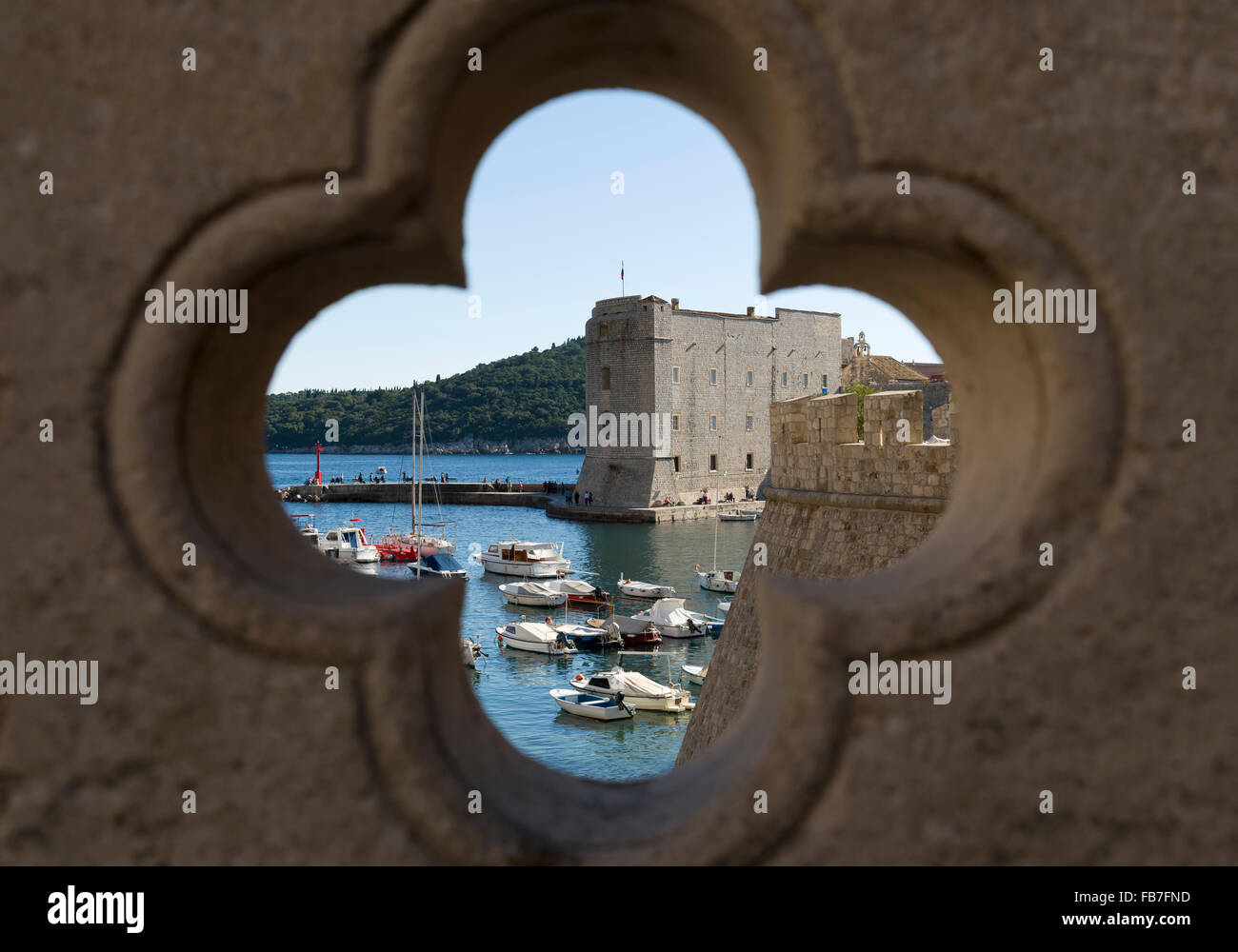 Vista del porto di Dubrovnik attraverso una pietra quatrefoil. Foto Stock
