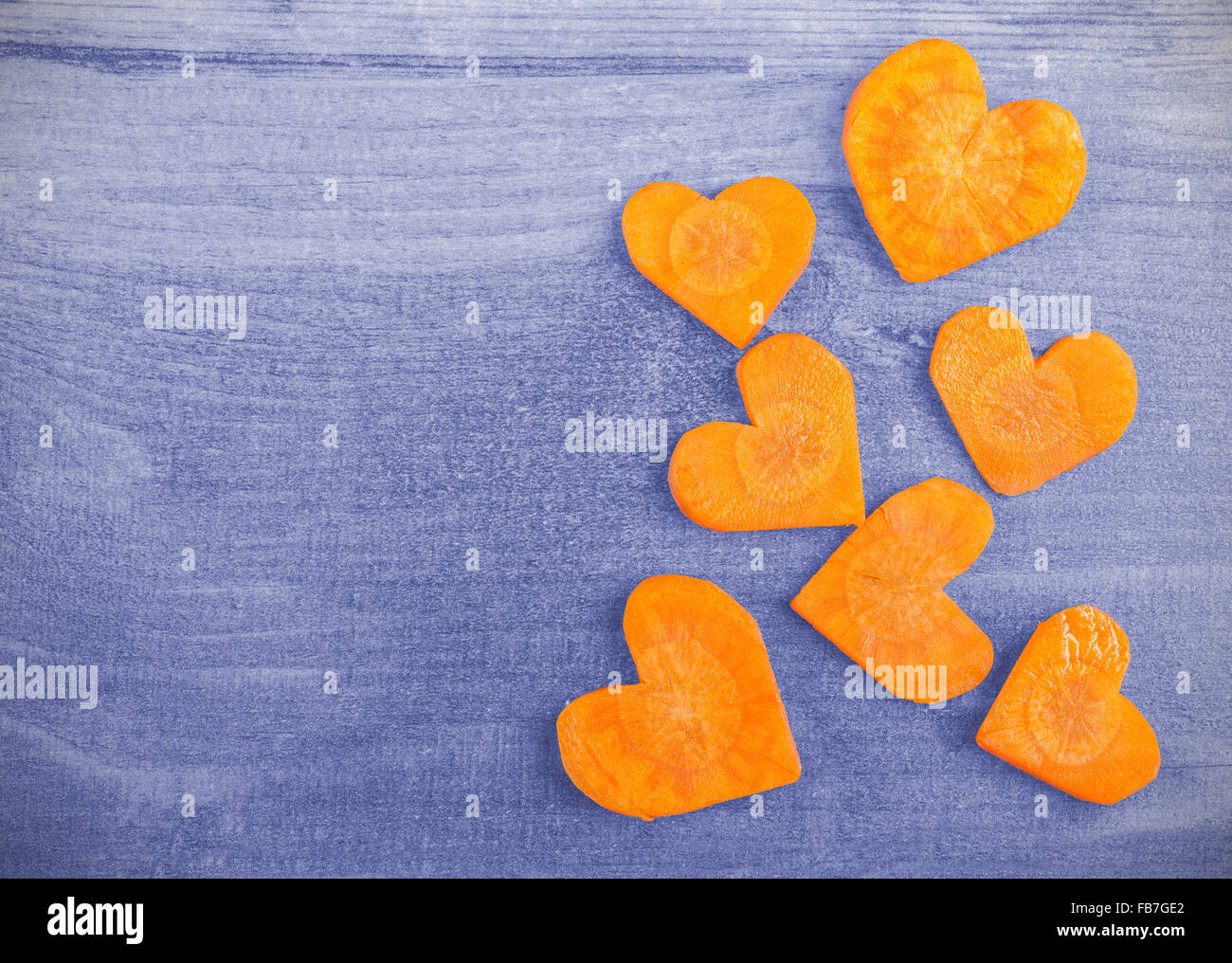 Vintage cuore stilizzato realizzato di carota su sfondo di legno, lo spazio per il testo. Foto Stock