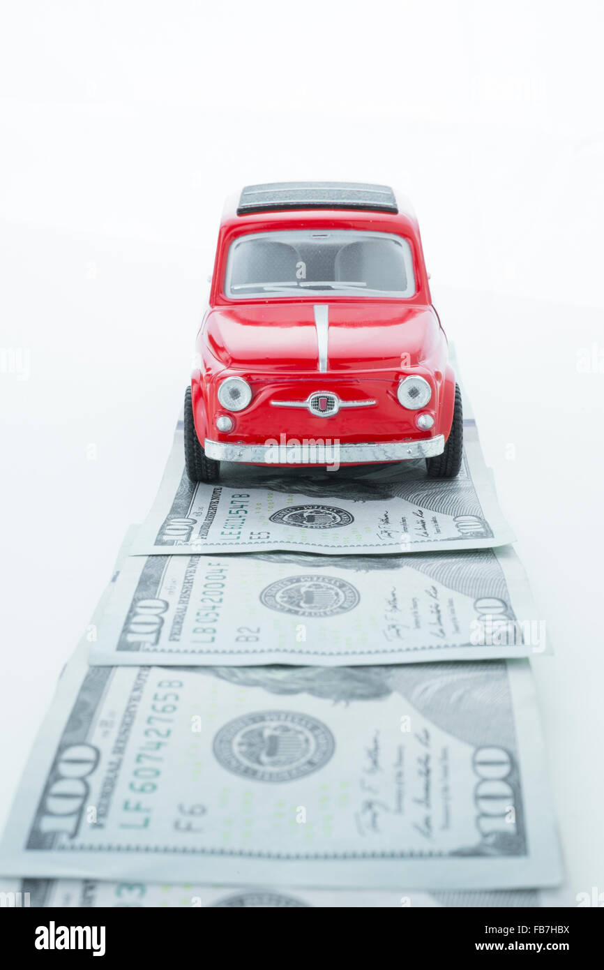 Un auto guidando su una strada pavimentata con denaro, che simboleggia la strada del successo Foto Stock