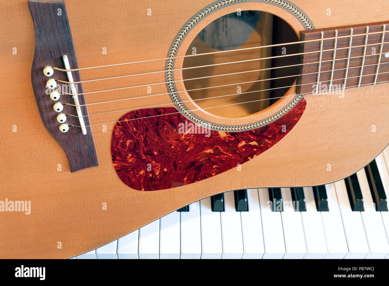 Chitarra acustica seduto sulla tastiera di pianoforte Closeup Foto Stock