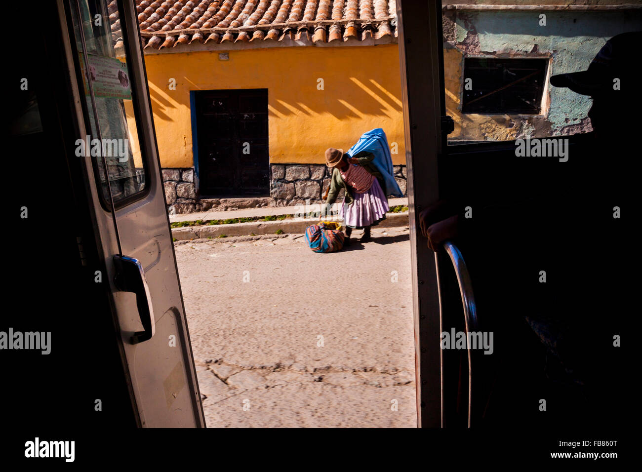 Una cholita raccoglie le sue cose per un mini-bus ride in Potosi, Bolivia. Foto Stock