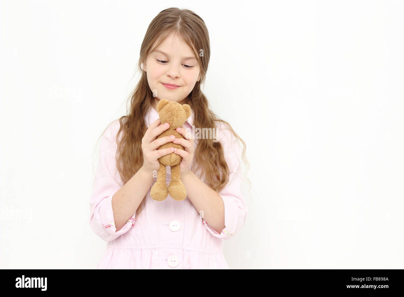 Little Girl holding orso giocattolo Foto Stock