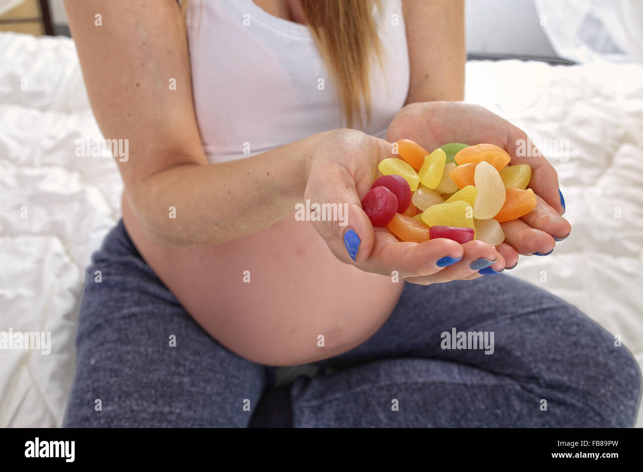 Donna incinta con caramella dolce Foto Stock
