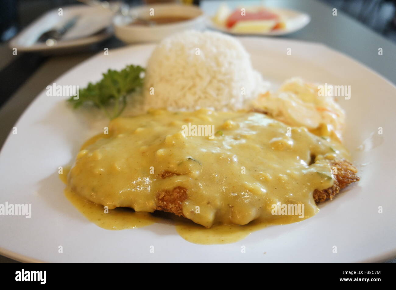 Filetto di pesce fritto nel pangrattato con salsa di burro e di riso Foto Stock