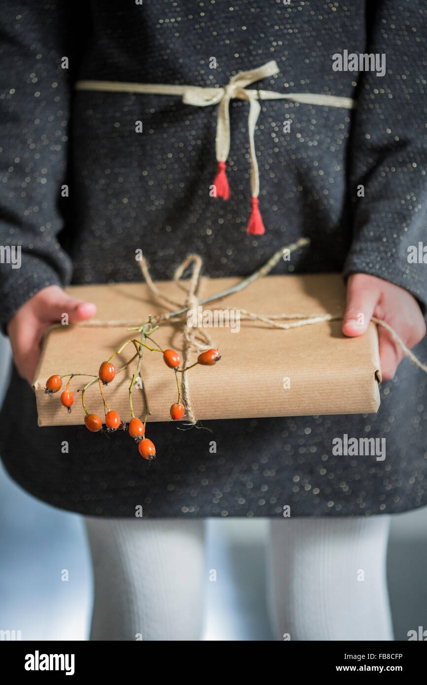 La Svezia, ragazza (6-7) azienda avvolto regalo di Natale Foto Stock