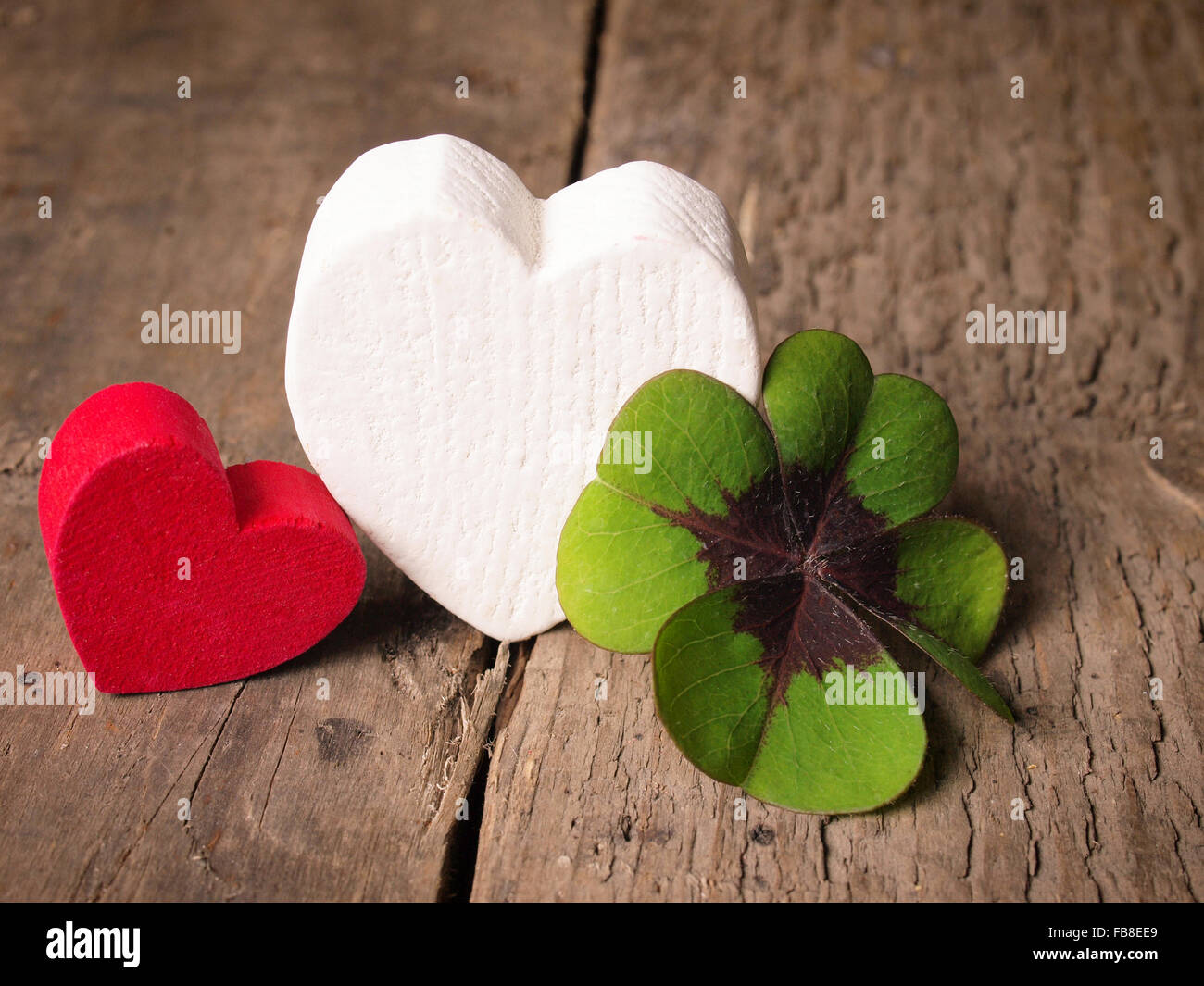 Due forme di cuore con un chiodo di garofano su un vecchio tavolo in legno Foto Stock