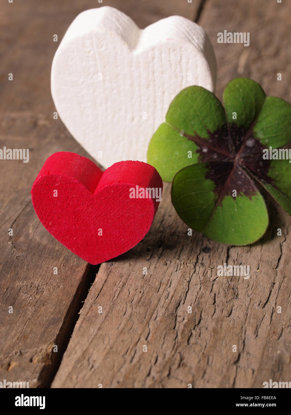 Cuore di forme con un chiodo di garofano su una tavola in legno rustico Foto Stock