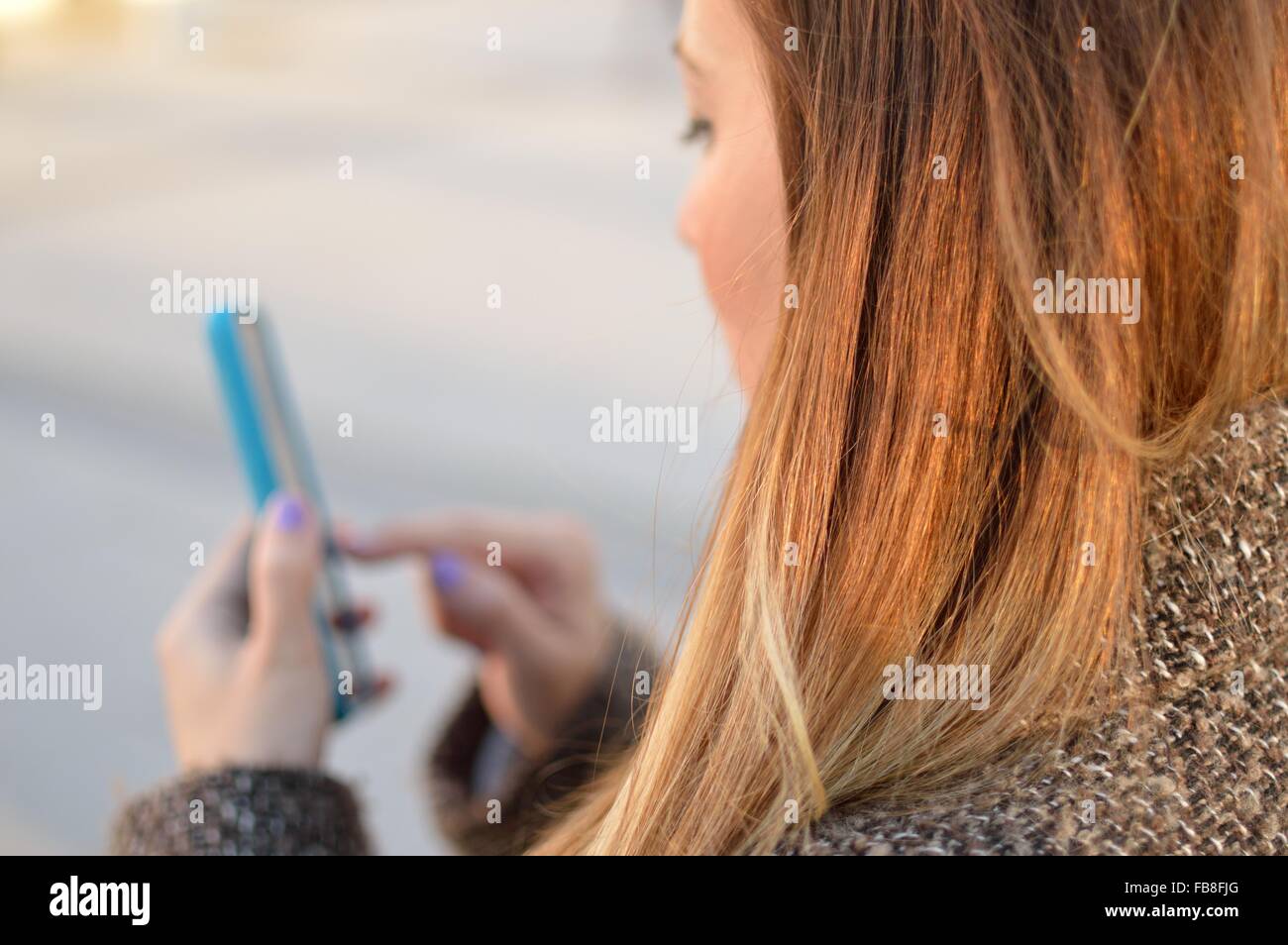 Immagine ritagliata della donna tramite telefono cellulare Foto Stock
