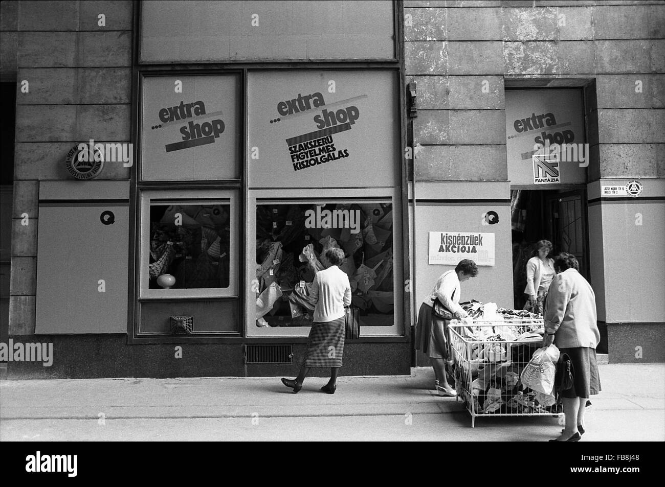 Sguardo su Bupapest al tempo degli anni Novanta. - 1990 - Ungheria / Budapest - sguardo su Bupapest al tempo degli anni Novanta. - Della vita quotidiana scena. Una donna fashion store. Una donna ungherese sta guardando la vetrina del negozio mentre gli altri due sono in ricerca in due grandi cesti. - Philippe Gras / Le Pictorium Foto Stock