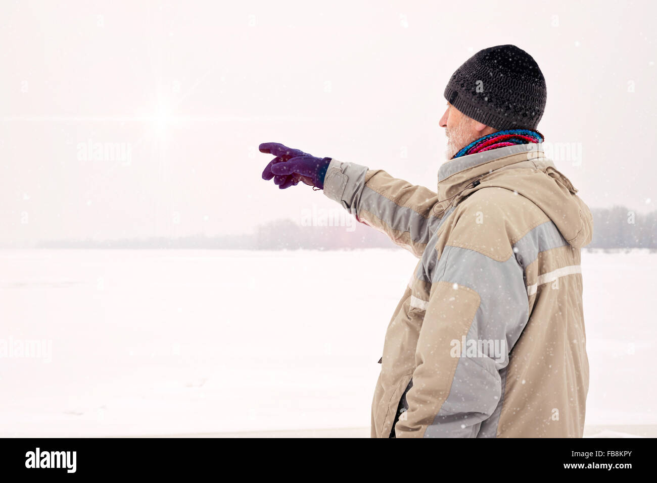 Un uomo con un tappo di lana, una giacca impermeabile e un cappello di lana  è indicare qualcosa con il dito vicino al fiume Dnieper dur Foto stock -  Alamy