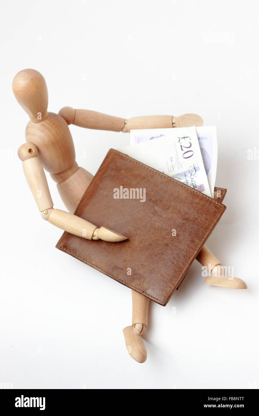 Denaro contante sterline nel portafoglio marrone e figurine Foto Stock