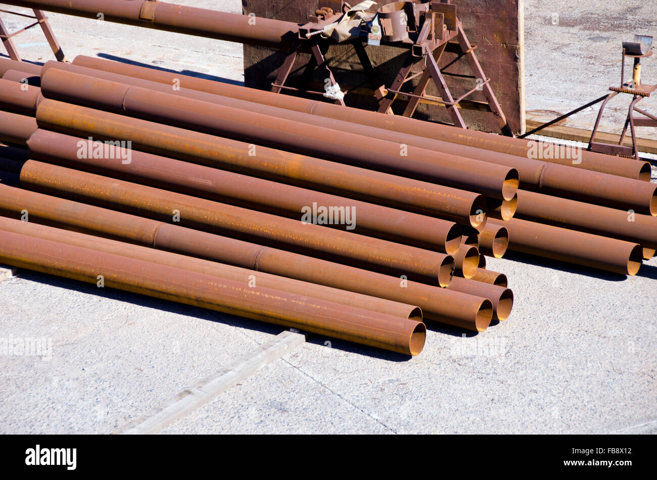 Soleggiato industriale marrone di tubi di ferro pila pila Foto Stock
