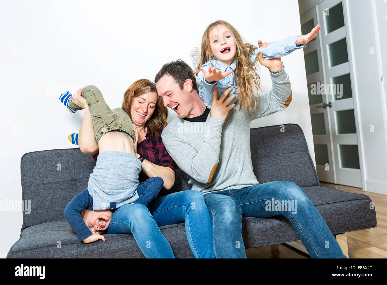 Bella famiglia seduti sul divano livingroom Foto Stock