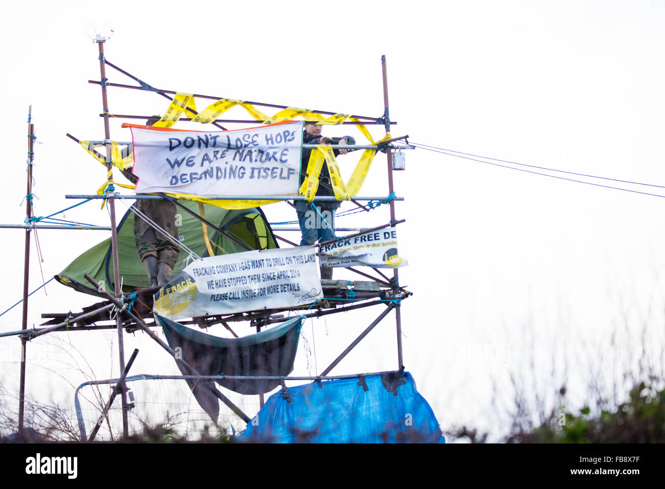 Upton, Cheshire. Xii gen, 2016. I manifestanti bloccati su di una torre a Upton anti fracking camp come ufficiali giudiziari e policemove a sfrattare il campo Credit: Jason Smalley / Alamy Live News Foto Stock
