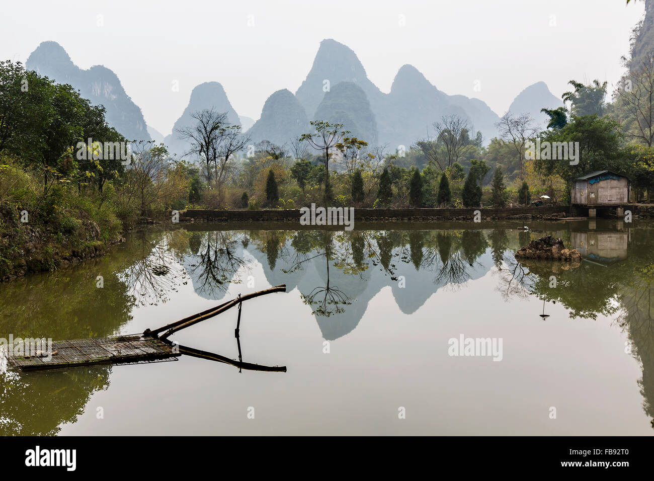 Riflessioni su un laghetto di Yangshuo del lato del paese. Foto Stock