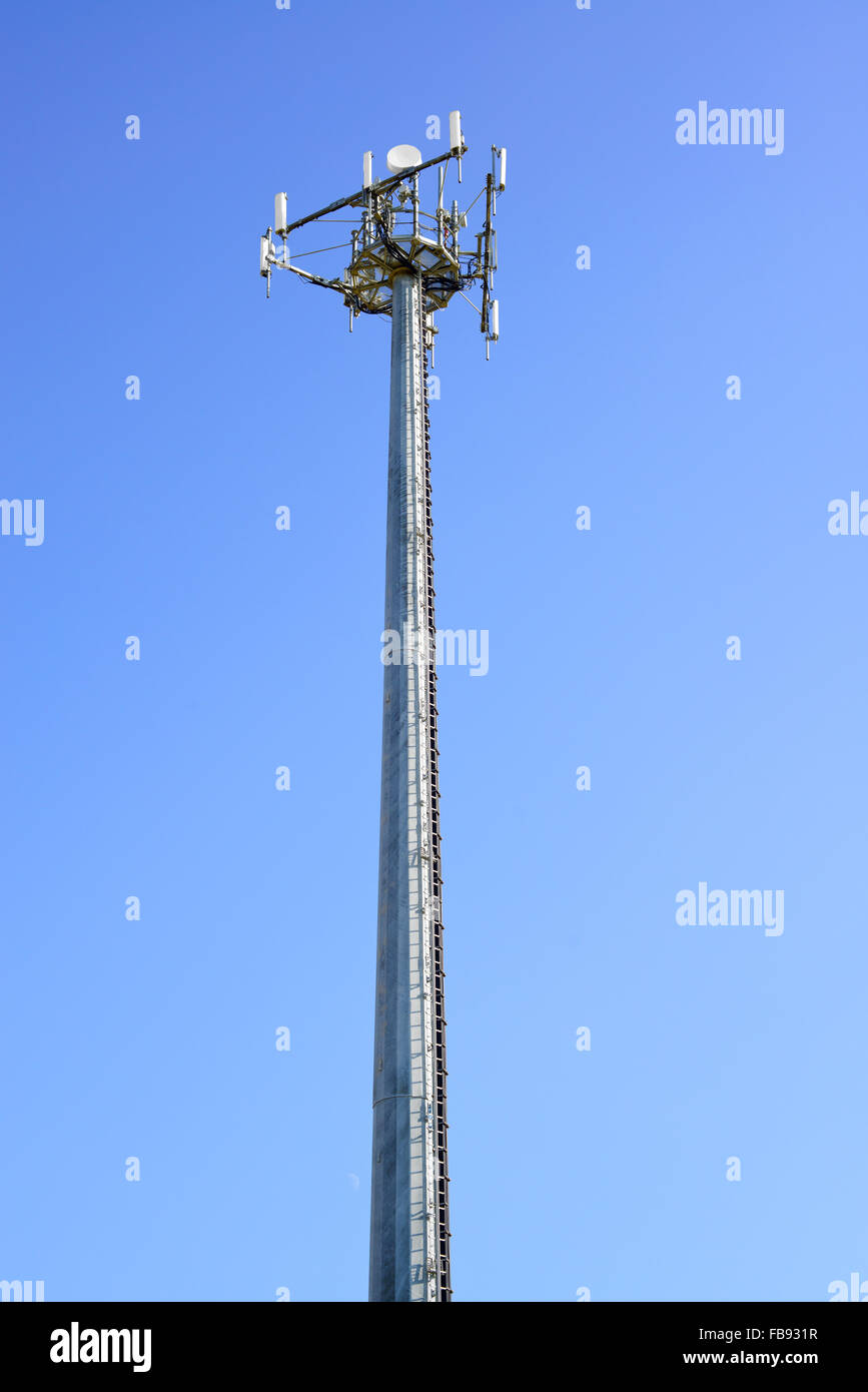 Torre di telecomunicazioni. Telefono mobile della stazione di base in un cielo blu sullo sfondo. Foto Stock