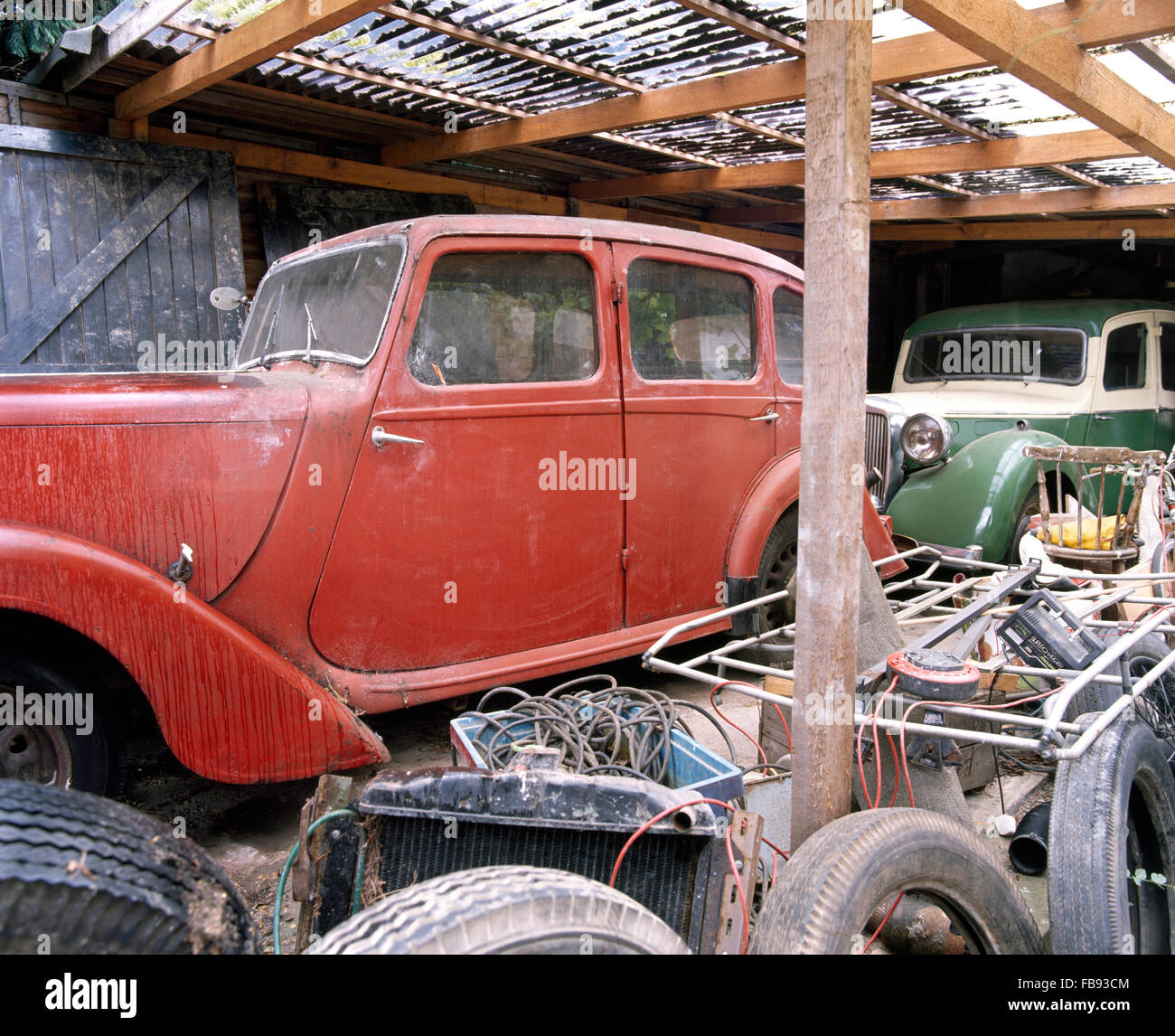 Il rosso e il verde auto d'epoca in un vecchio garage Foto Stock