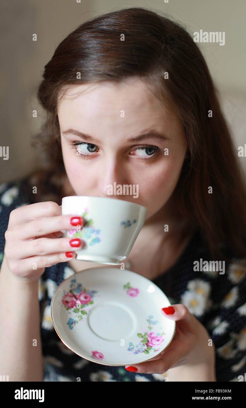 Ritratto di una giovane donna di bere da una coppa di cina Foto Stock