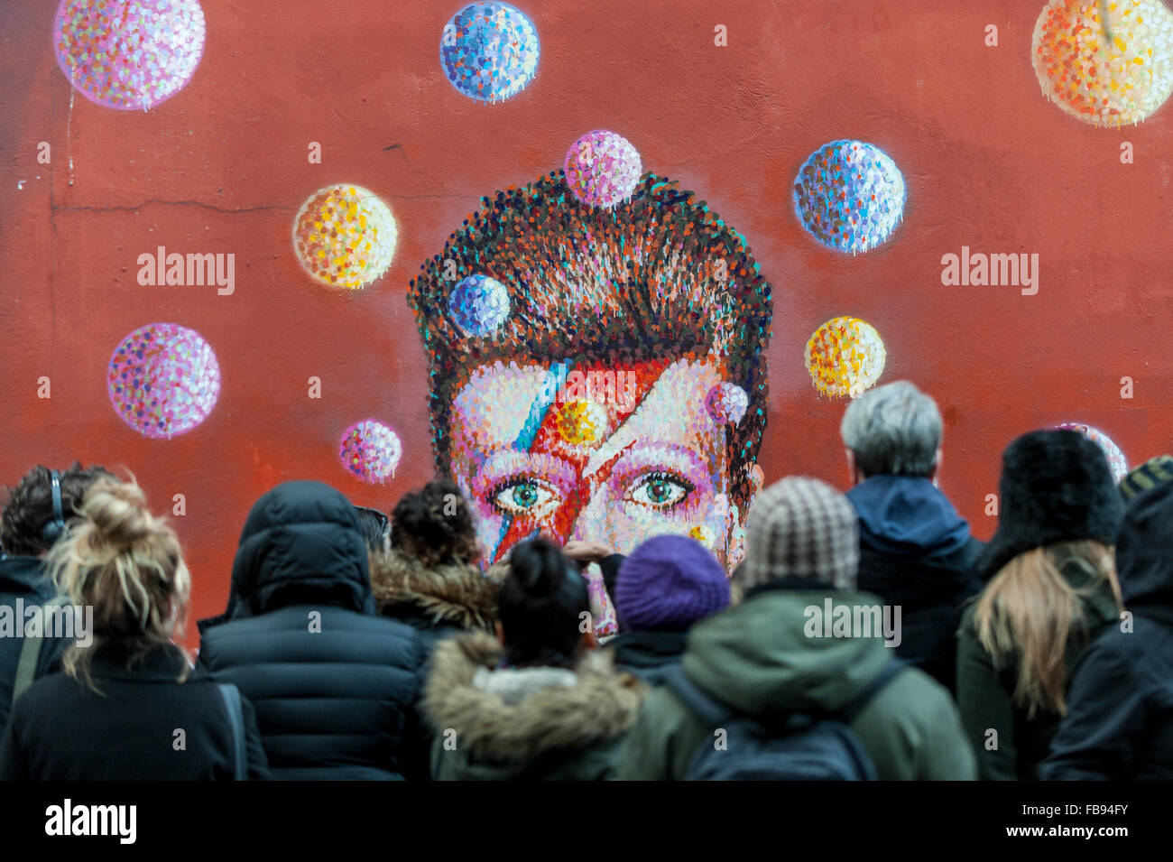 Londra, Regno Unito. Il 12 gennaio 2016. Ventole continuano a visitare il murale di David Bowie a Brixton per pagare i loro rispetti e lasciare i tributi seguenti notizie che l'iconica 69 anno vecchio cantante era morto di cancro il giorno precedente. Credito: Stephen Chung / Alamy Live News Foto Stock
