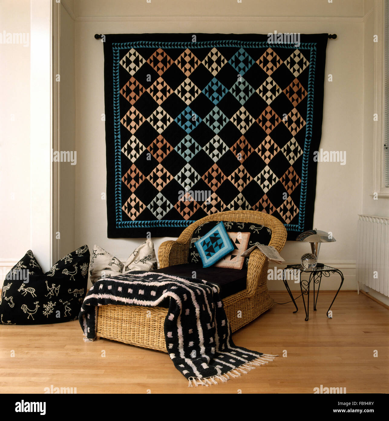 Tappeto tessuto da parete in soggiorno con un nero+bianco buttare in lana su una wicker chaise longue Foto Stock