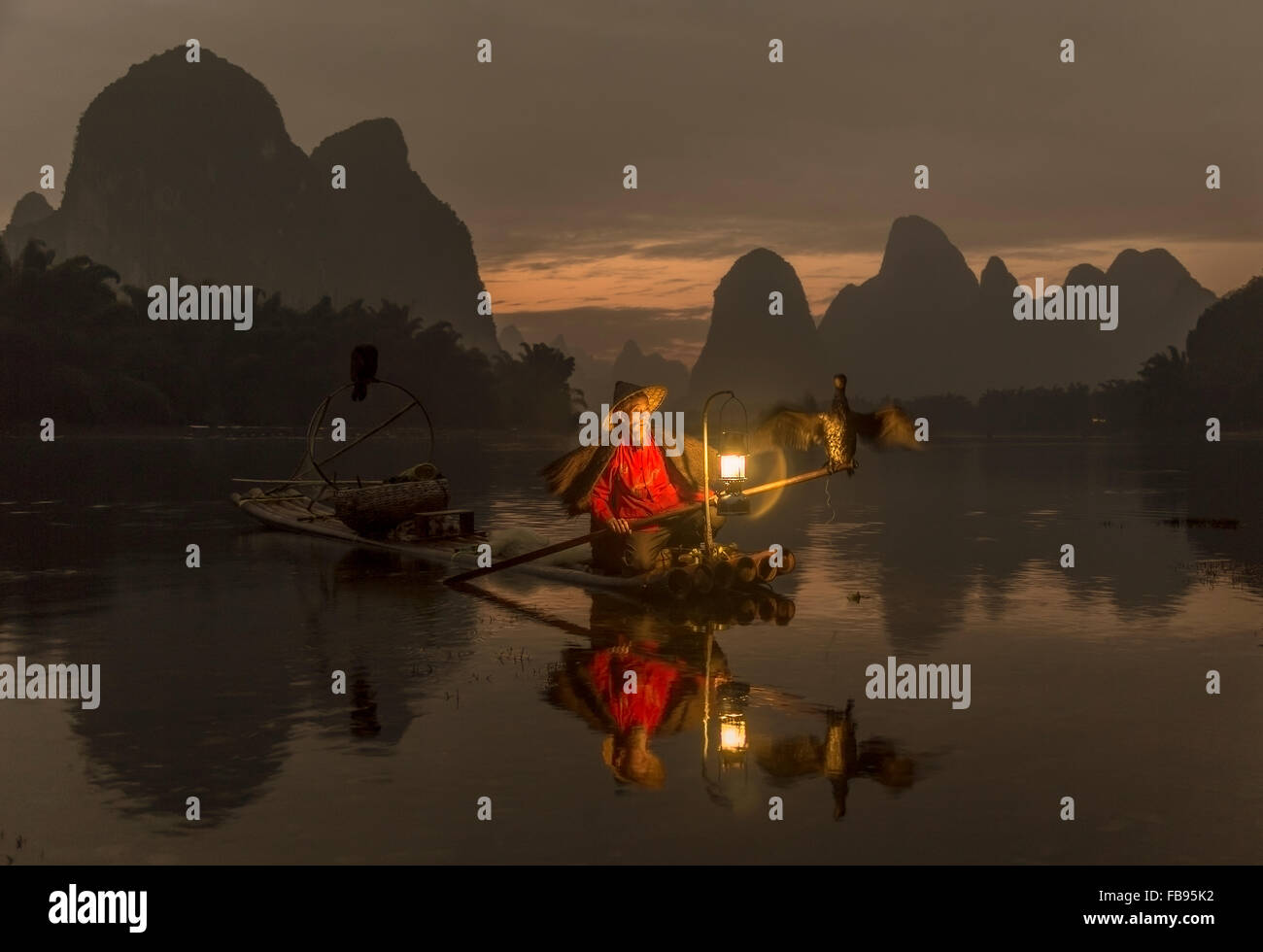 Il fiume Li - Xingping, Cina. Gennaio 2016 - un pescatore pronto per andare a pesca di notte. Foto Stock