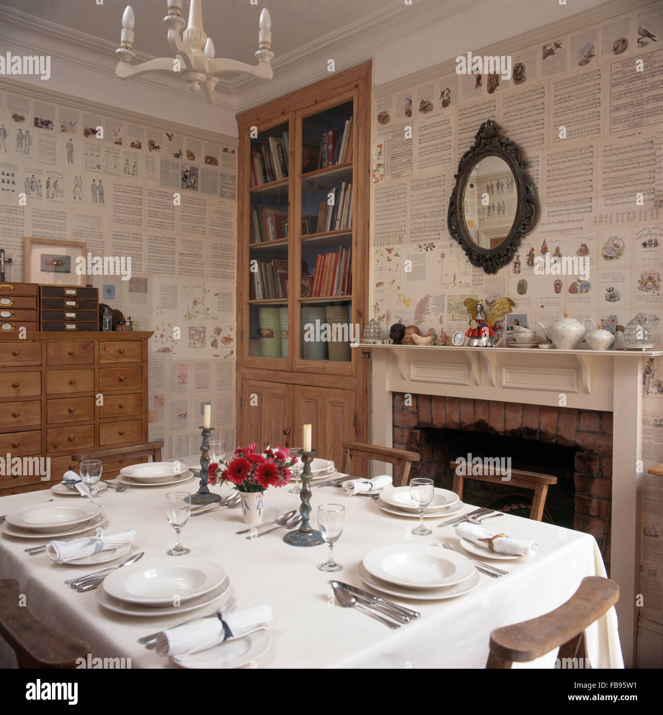 Croccante panno bianco sul tavolo per la cena in novanta sala da pranzo con pareti tappezzate con vecchie pagine di riviste Foto Stock