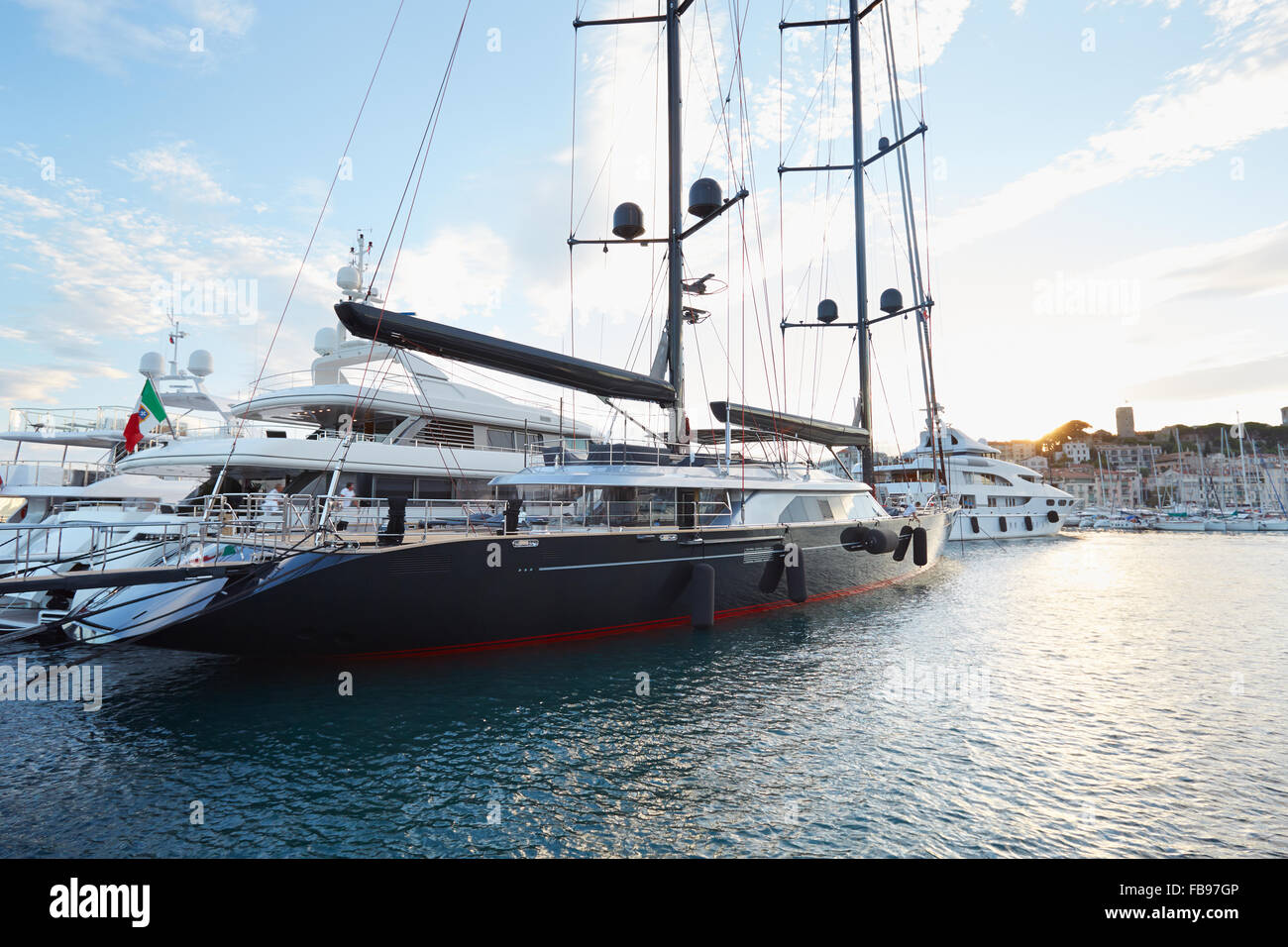 Moderno un nero rosso barca a vela di Perini Navi visto nel porto di La luce del tramonto in Cannes Foto Stock