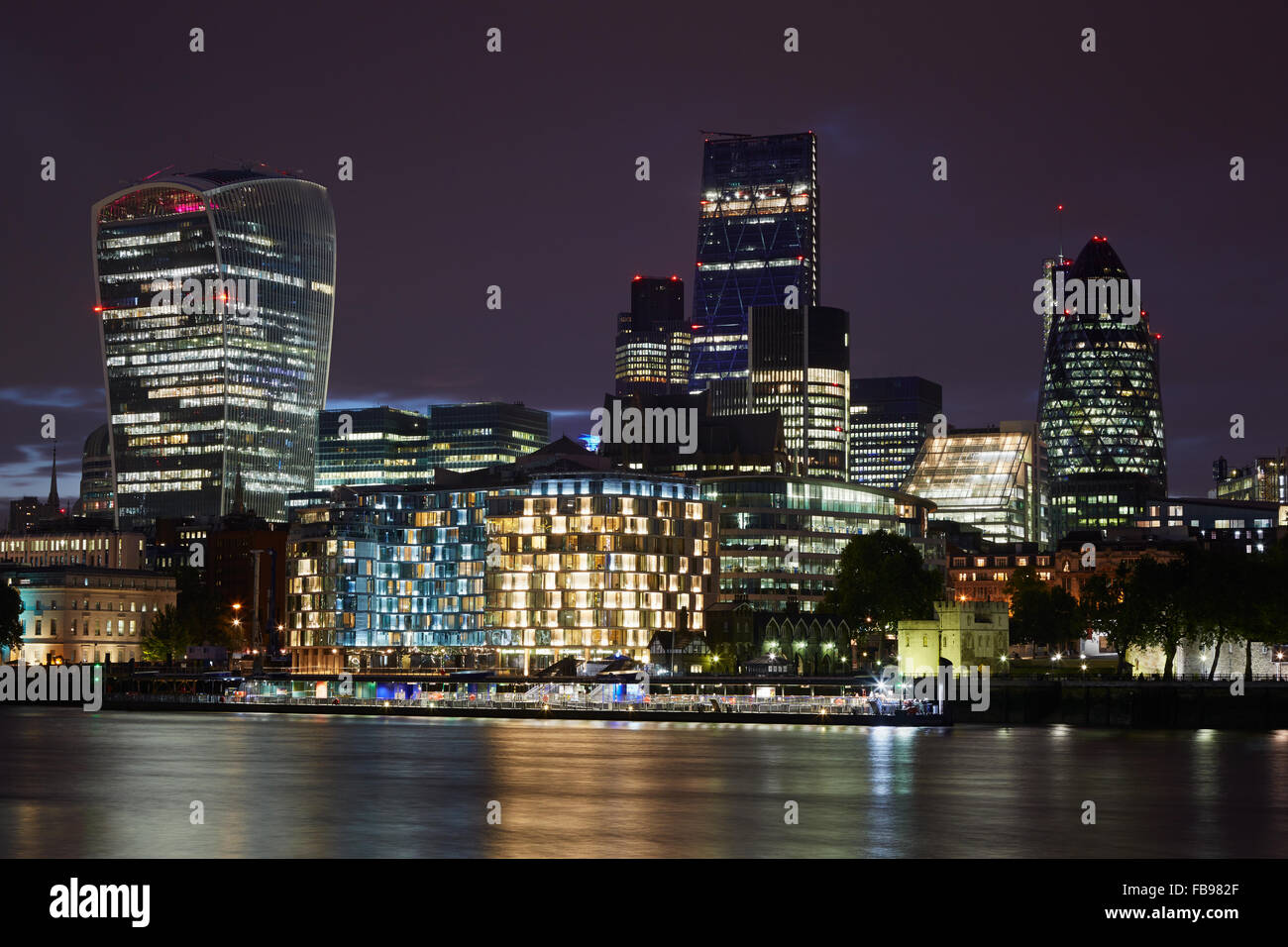 Londra grattacieli dello skyline illuminata di notte con il fiume Tamigi Foto Stock